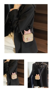 Mini straw crossbody bag with pink bow and silver flower detail on model wearing black suit