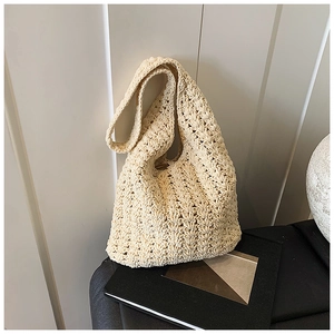 Detailed close-up of the beige hollow crochet knit pattern on a summer beach tote bag