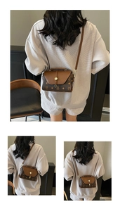 Detail view of a vintage brown crossbody bag with logo print and gold clasp closure
