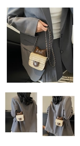 Detail of straw woven mini bag featuring large leather bow and flower metal clasp