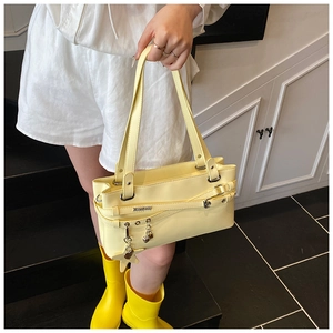 Détail du sac cabas jaune rectangulaire avec lanières et breloques en forme d'étoile