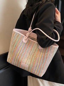 Colorful woven straw tote bag with pink straps and knot detail for fashion travel