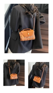 Detail view of brown vintage satchel with classic monogram pattern and gold hardware