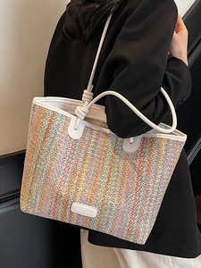 Colorful woven straw tote bag with rainbow pattern and white knotted shoulder straps