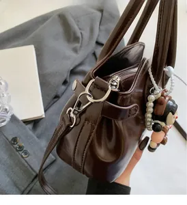 Dettaglio della borsa in pelle lucida testa di moro con minuterie argentate e charm