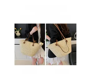 Detail of light beige straw tote bag showing both hand-carry and shoulder strap styles