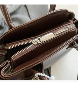Dettaglio della cerniera argentata scorrevole su una borsa in pelle marrone vintage
