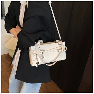 Détail d'un sac à bandoulière crème en similicuir avec boucles et breloque étoile