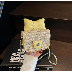 Detail of yellow straw crossbody bag with leather bow and camellia metal lock