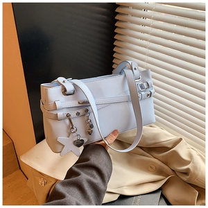 Détails d'un sac bandoulière bleu clair avec pendentifs étoiles et boucles argent