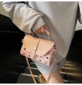 Detail view of pink PU leather handbag featuring bear print and gold metal buckle clasp