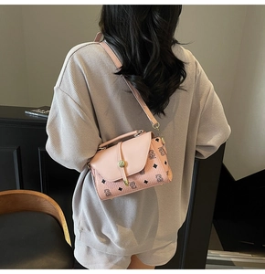 Rear view of a light pink crossbody bag with vintage TB monogram print on smooth leather