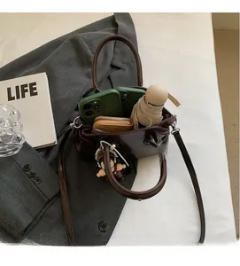 Dettaglio di una borsa a mano marrone scuro in pelle cerata con capiente spazio interno