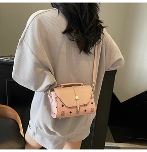 Lifestyle shot of pink mini crossbody bag with bear print and metal clasp closure