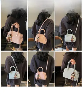 Modella che indossa mini borse vintage in pelle cerata in rosa tenue e azzurro