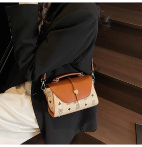 Close-up of printed patterns and metal clasp on the vintage brown leather crossbody bag