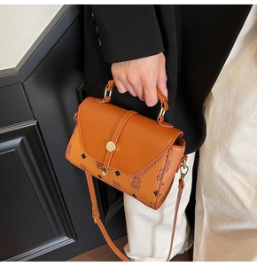 Close-up of brown crossbody bag with gold lock and vintage cartoon bear prints