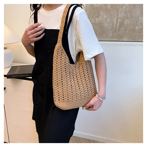 Detail of khaki crochet woven tote bag showing the hollow grid texture and wide shoulder strap
