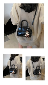 Dettaglio della borsa in pelle cerata nera con logo MIKUCCI e accessorio per bambole
