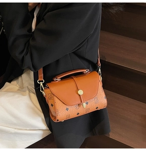 Detail of vintage brown crossbody bag featuring bear pattern and golden twist lock