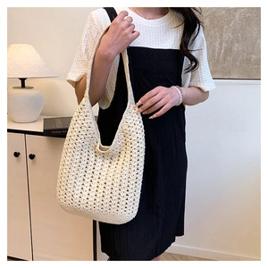 Detail of beige crochet tote bag showing hollow weave texture and thick woven base