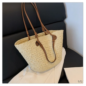 Detail of straw woven tote bag with brown leather straps on a contrast chair