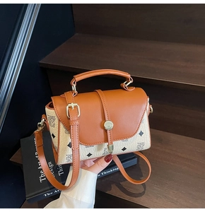 Detail of vintage tote bag with bear print, leather flap, and gold metal lock clasp