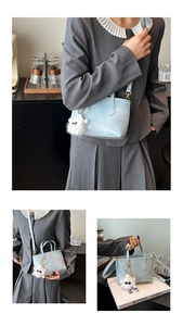 Detail of light blue leather bucket bag with plush monster charm and gold hardware