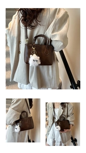 Detail of dark brown faux leather bucket bag with a cute white fuzzy monster pendant