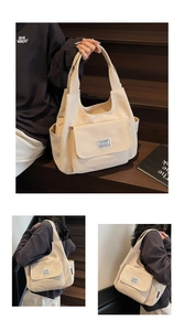 Detail of minimalist beige canvas tote bag showing side pockets and flap pocket design
