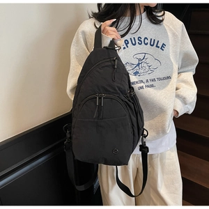 Vue détaillée du sac de poitrine en nylon noir avec trois fermetures éclair et sangle