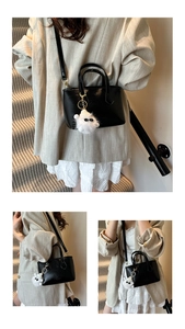 Detail of minimalist black PU leather bucket bag with cute white ghost charm accessory