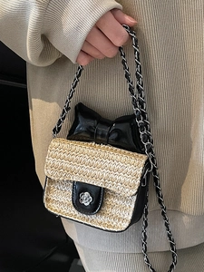 Mini straw woven crossbody bag with camellia buckle and decorative black bow detail