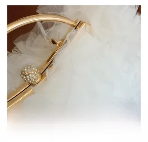 Close-up of elegant gold hardware handle with sparkling rhinestone ball on white tulle bag