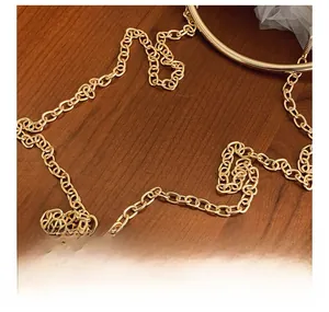 Detailed macro view of the glossy gold metal chain strap on a brown wooden texture