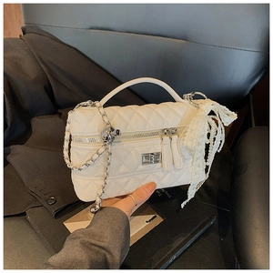 Detail of white quilted crossbody bag with delicate pearl lace bow and silver hardware