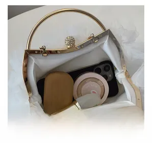 Interior view showing the capacity of a white lace evening bag with gold handle