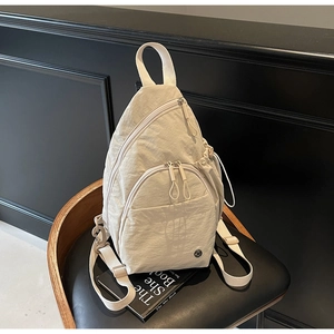 Détail du sac de poitrine en nylon blanc crème avec poche latérale à cordon et texture