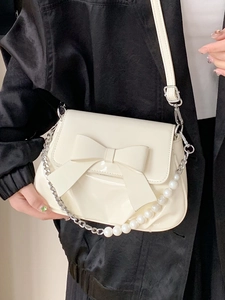 Cream chic crossbody bag with large bow and pearl chain strap for elegant style