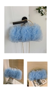 Detail of light blue lace ruffle handbag featuring gold ring handle and chain strap
