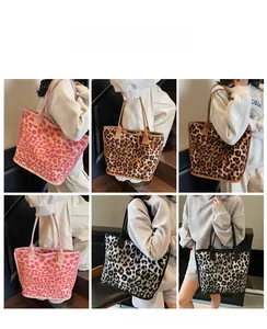 Detail view of large leopard print tote bags in pink, brown, and grey on a shoulder bag