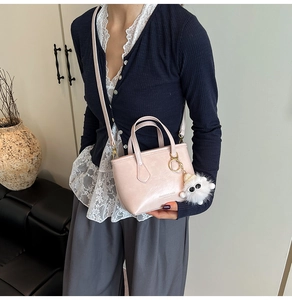 Detail of light pink bucket bag featuring a soft faux fur monster charm decoration