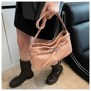Vue détaillée de la texture plissée verticale et de la bandoulière du sac rose