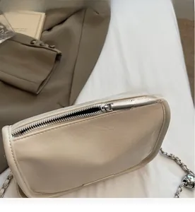 Detail of the smooth silver zipper and creamy soft leather texture on a pillow bag