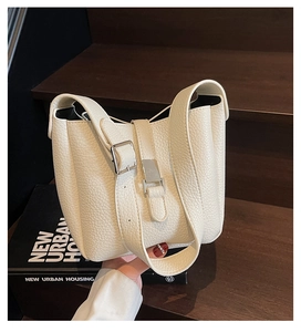 Detailed macro view of white litchi pattern leather and silver buckle on the stylish tote bag