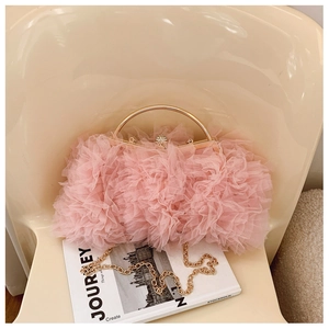 Detail of pink ruffled tulle clutch bag with golden metal handle and diamond ball clasp