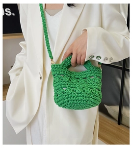 Detailed close-up of green woven basket bag featuring hollow texture and golden metal hooks