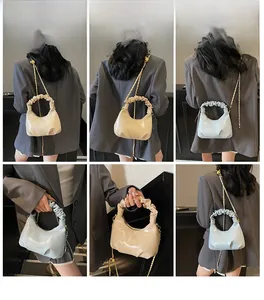 Détail de la poignée plissée et de la chaîne dorée du sac hobo en plusieurs coloris