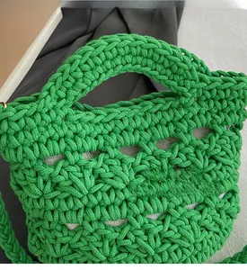 Close-up of vibrant green woven handbag showing detailed knit texture and inner lining