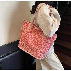 Pink and orange leopard print tote bag shown on shoulder in a lifestyle setting